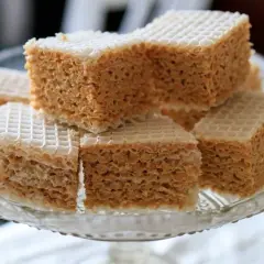Słodkie wafle przekładane kremem z mleka w proszku, ułożone na szklanej paterze.