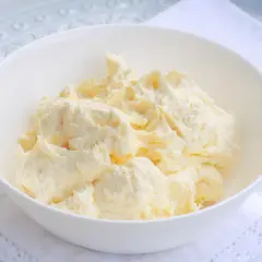 Puszysta masa budyniowa z mascarpone w białej misce, gotowa do użycia w deserach.