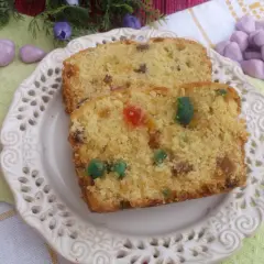 Keks według starego przepisu, z kolorowymi bakaliami, na ozdobnym talerzyku.