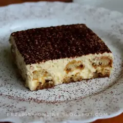 Pyszne tiramisu, czyli zabajone, na białym talerzu, posypane kakao.