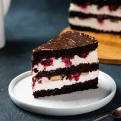 Obłędny tort czekoladowy z mascarpone i owocami, z malinami i bananami, polany czekoladą.