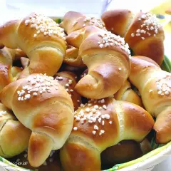 Koszyk pełen mięciutkich rogalików drożdżowych, posypanych cukrem. Idealne na śniadanie, zgodnie z przepisem na pyszne wypieki.