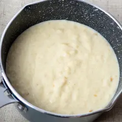 Kremowy sos z mascarpone w rondelku, gotowy do podania z deserem.