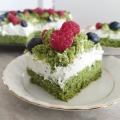 Zielone ciasto leśny mech na dużą blachę, przełożone kremem z serkiem mascarpone, ozdobione malinami i borówkami.