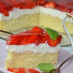 Puszysty biszkopt z truskawkami i mascarpone, oblany galaretką. Idealny deser na letnie popołudnie.
