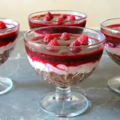 Pyszna galaretka z mascarpone i malinami w pucharkach. Warstwy czekolady, kremu i owoców kuszą smakiem.