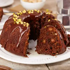 Pyszna, wilgotna babka czekoladowa z bakaliami, polana polewą i posypana pistacjami. Idealna na deser.