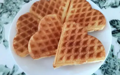 Sześć złotych gofrów w kształcie serca na białym talerzu. Idealne na najprostszy przepis na gofry.