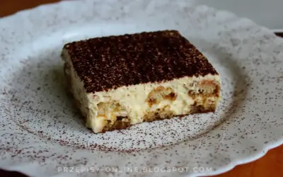 Pyszne tiramisu, czyli zabajone, na białym talerzu, posypane kakao.