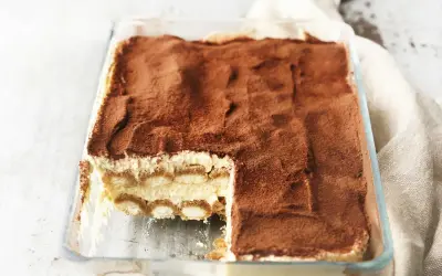 Pyszne tiramisu z mascarpone w szklanej formie, posypane kakao. Idealny sprawdzony przepis na deser.
