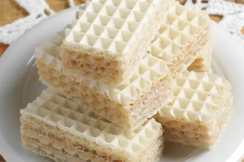 Stos puszystych wafli przełożonych kremem, gotowych do jedzenia. Ta masa do wafli wygląda pysznie!