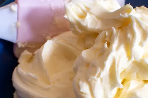Puszysty, prosty krem z mascarpone bez śmietany, idealny do deserów. Widać różową łopatkę do mieszania.