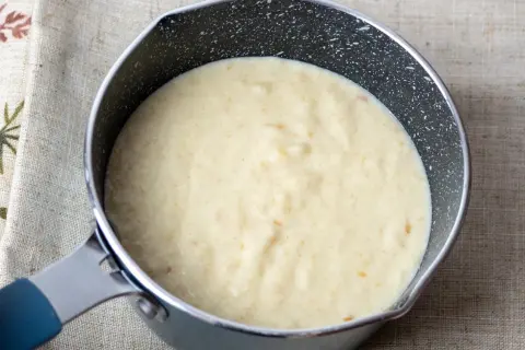 Kremowy sos z mascarpone w rondelku, gotowy do podania z deserem.