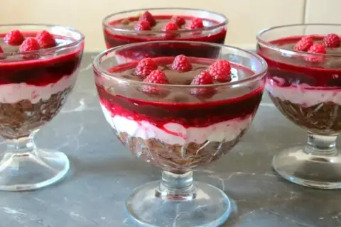 Pyszna galaretka z mascarpone i malinami w pucharkach. Warstwy czekolady, kremu i owoców kuszą smakiem.