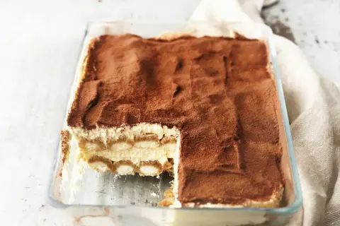 Pyszne tiramisu z mascarpone w szklanej formie, posypane kakao. Idealny sprawdzony przepis na deser.
