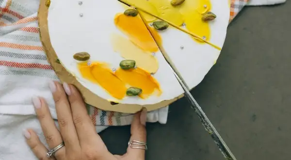 Delikatny tort z pistacjami i żółtym kremem. Zobacz, jak kroić tort, by zachować jego piękny wygląd.