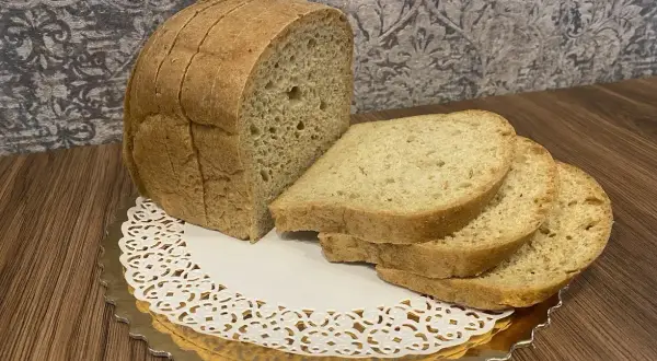 Chleb keto, pokrojony w kromki, prezentuje się apetycznie na złotym talerzyku. Idealny na dietę niskowęglowodanową.