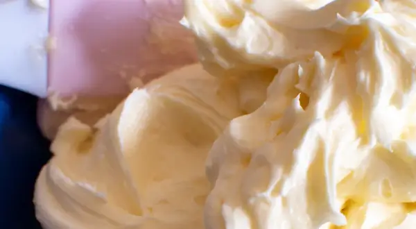 Puszysty, prosty krem z mascarpone bez śmietany, idealny do deserów. Widać różową łopatkę do mieszania.