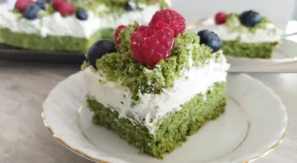 Zielone ciasto leśny mech na dużą blachę, przełożone kremem z serkiem mascarpone, ozdobione malinami i borówkami.