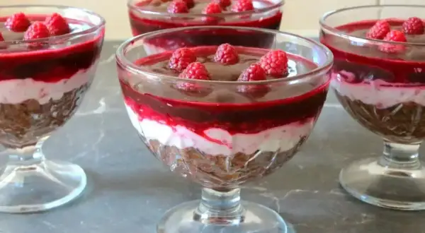 Pyszna galaretka z mascarpone i malinami w pucharkach. Warstwy czekolady, kremu i owoców kuszą smakiem.