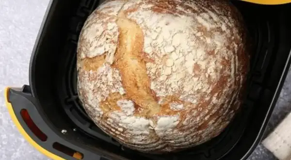 Chleb z airfryer, rumiany i posypany mąką, czeka na wyjęcie.