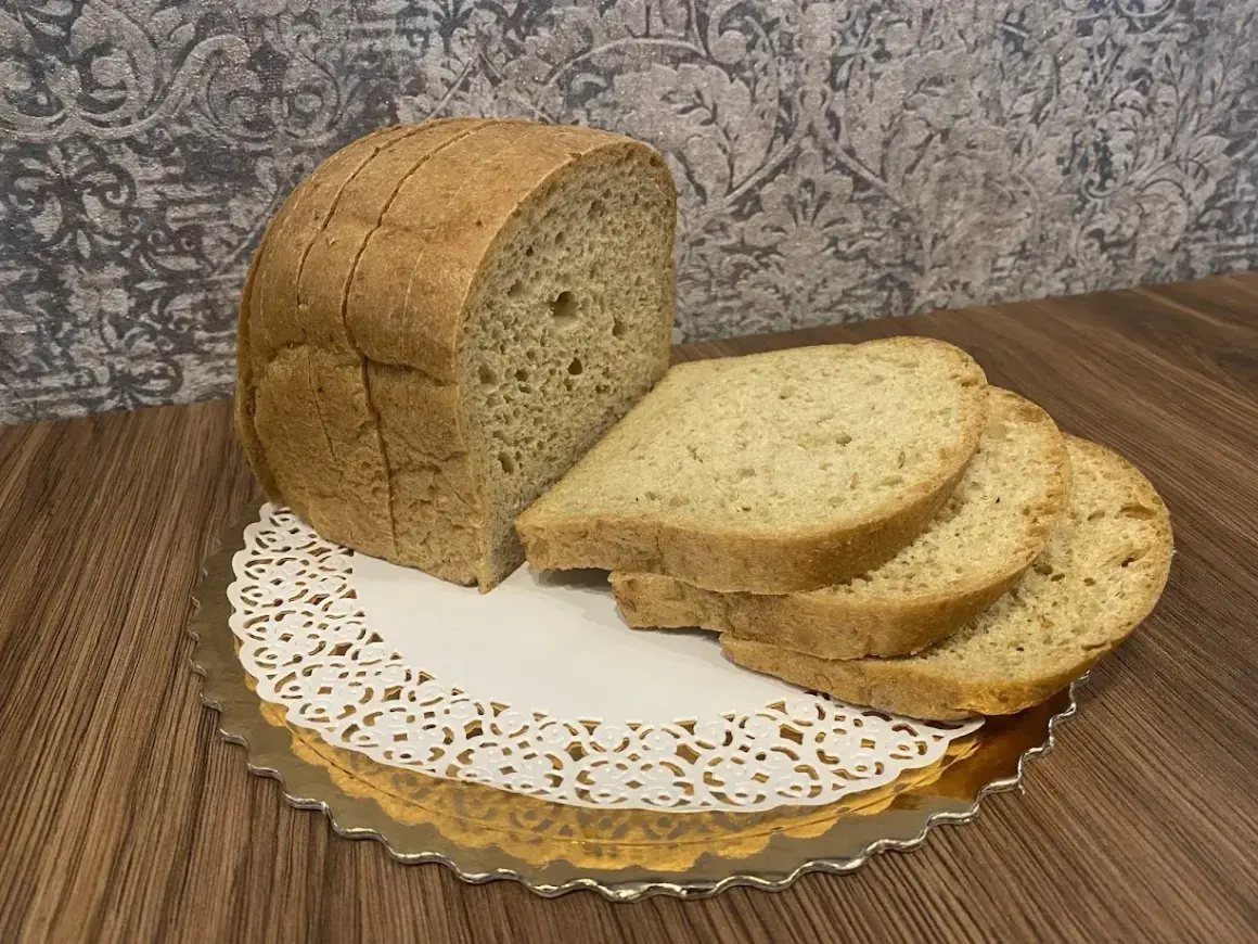 Chleb keto, pokrojony w kromki, prezentuje się apetycznie na złotym talerzyku. Idealny na dietę niskowęglowodanową.