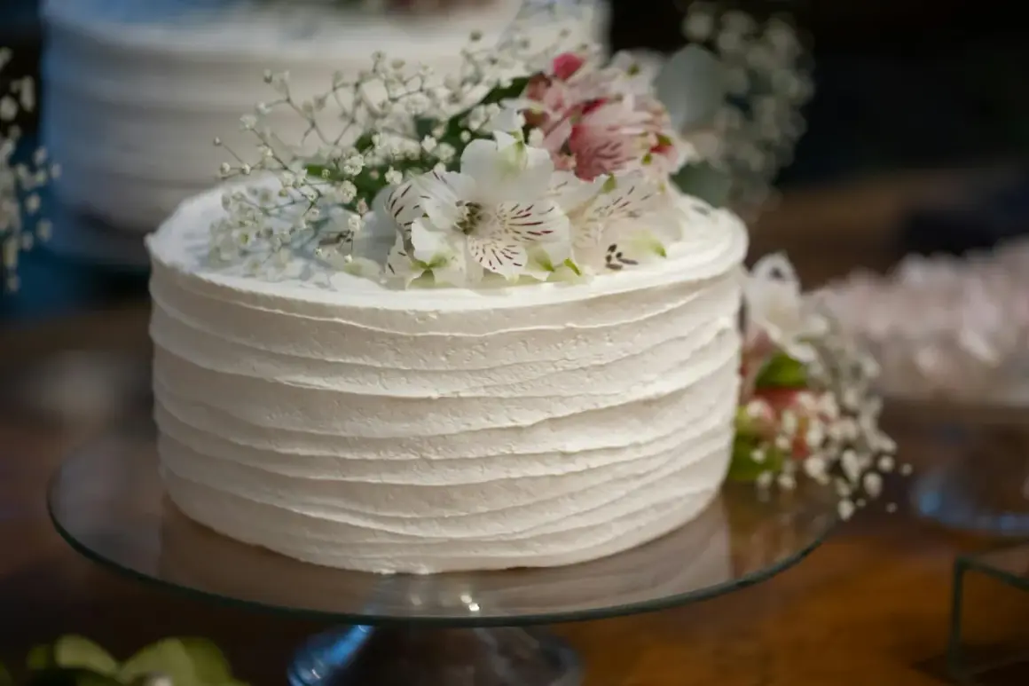 Eleganckie ciasta na komunie, udekorowane świeżymi kwiatami, czekają na wyjątkowy dzień.