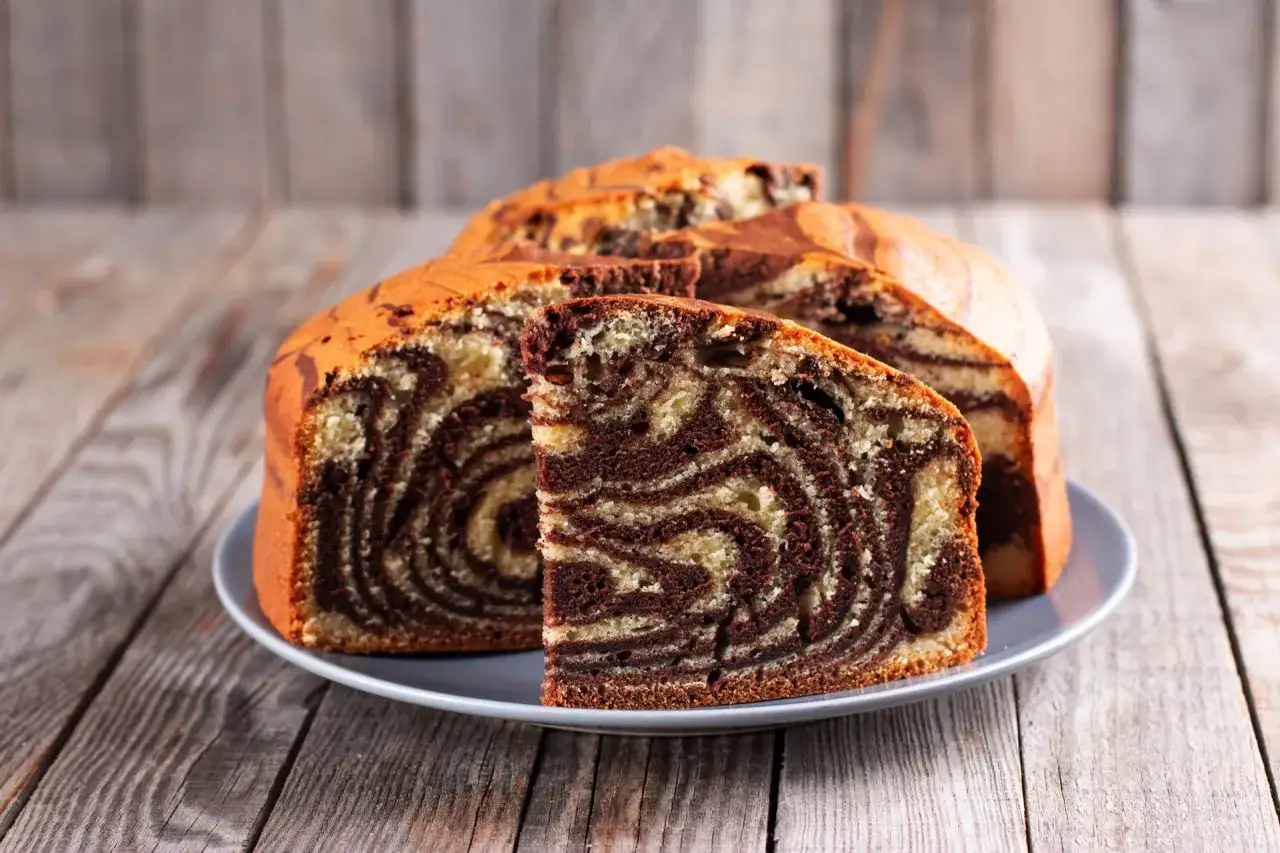 Pyszne ciasto z airfryer z efektem zebry, pokrojone na talerzu, prezentuje swoje czekoladowo-waniliowe paski.