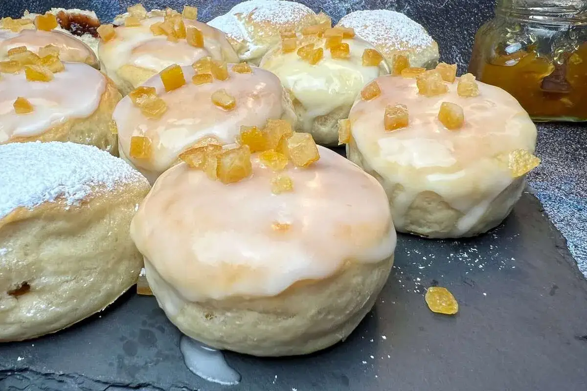Szybkie pączki z piekarnika, polane lukrem i posypane kandyzowaną skórką pomarańczową. Idealne na szybką przekąskę.