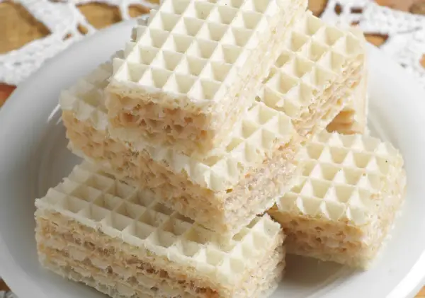 Stos puszystych wafli przełożonych kremem, gotowych do jedzenia. Ta masa do wafli wygląda pysznie!