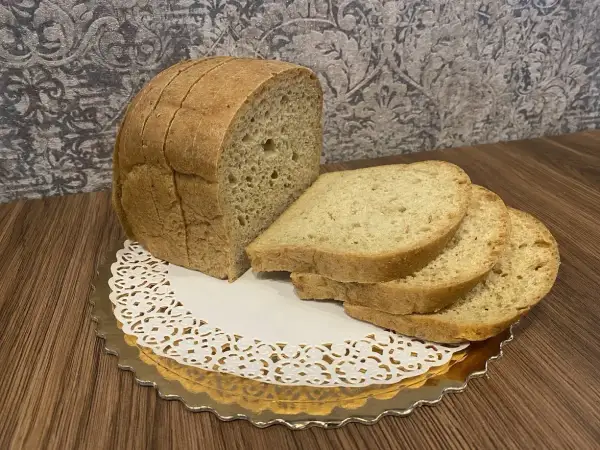 Chleb keto, pokrojony w kromki, prezentuje się apetycznie na złotym talerzyku. Idealny na dietę niskowęglowodanową.