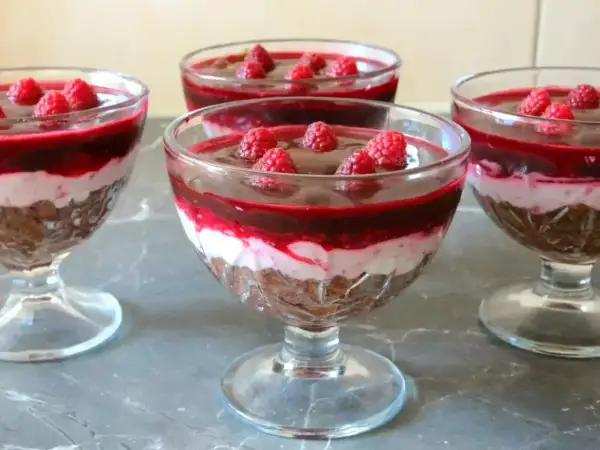 Pyszna galaretka z mascarpone i malinami w pucharkach. Warstwy czekolady, kremu i owoców kuszą smakiem.