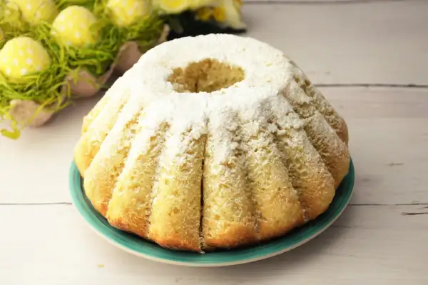 Najłatwiejsza babka drożdżowa, puszysta i lekka, posypana cukrem pudrem. Idealna na Wielkanoc, obok żółtych jajek w zielonej trawie.